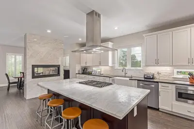 a kitchen with a large island with bar stools at Beautiful Denver City Park Home in Denver