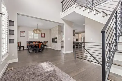 a living room with a staircase and a dining room at Beautiful Denver City Park Home in Denver