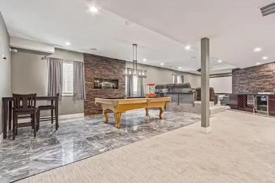a living room with a pool table and a kitchen at Beautiful Denver City Park Home in Denver