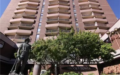 a statue of a man standing in front of a building at Brooks Tower Downtown Denver Furnished Apartment in Denver