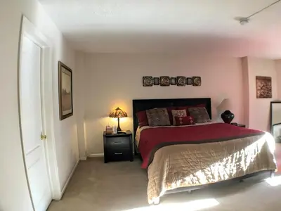 a bedroom with a bed with a red comforter at Brooks Tower Downtown Denver Furnished Apartment in Denver