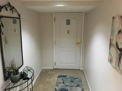 a hallway with a white door and a mirror at Brooks Tower Downtown Denver Furnished Apartment in Denver