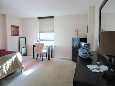a bedroom with a bed and a desk and a table at Brooks Tower Downtown Denver Furnished Apartment in Denver