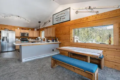 a kitchen with wooden walls and a large window at Cozy Mountain Cabin with Stunning Views in Idaho Springs