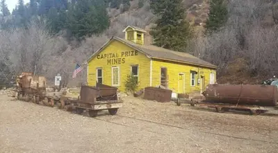 a yellow building with two trucks in front of it at Cozy Mountain Cabin with Stunning Views in Idaho Springs