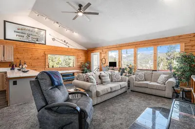 a living room with two couches and a kitchen at Cozy Mountain Cabin with Stunning Views in Idaho Springs