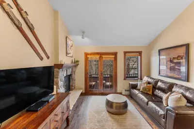 a living room with a leather couch and a tv at Arapahoe Lodge 8137 in Keystone