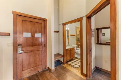 a hallway with a wooden door and a bathroom at Arapahoe Lodge 8137 in Keystone