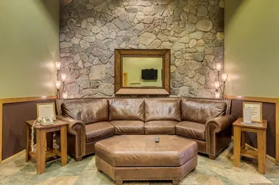 a living room with a brown leather couch and a mirror at Arapahoe Lodge 8137 in Keystone