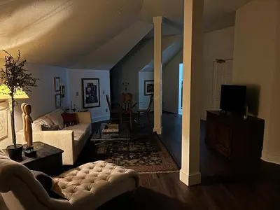 a living room with a couch and a tv at Innkeeper Suite at The Currier Inn in Greeley