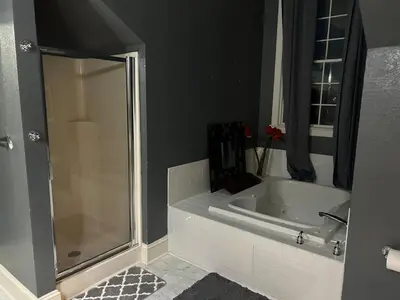 a bathroom with a shower and a bath tub at Innkeeper Suite at The Currier Inn in Greeley