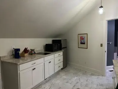 a kitchen with a counter top with a microwave at Innkeeper Suite at The Currier Inn in Greeley
