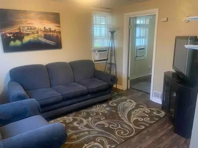 a living room with a couch and a tv at Cute 1 Bdrm Bungalow - New Flooring! in Greeley