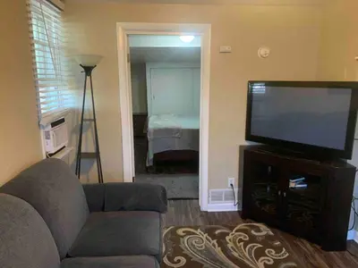 a living room with a couch and a flat screen tv at Cute 1 Bdrm Bungalow - New Flooring! in Greeley