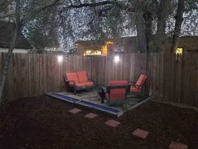 a backyard with two chairs and a table and a fence at Cute 1 Bdrm Bungalow - New Flooring! in Greeley
