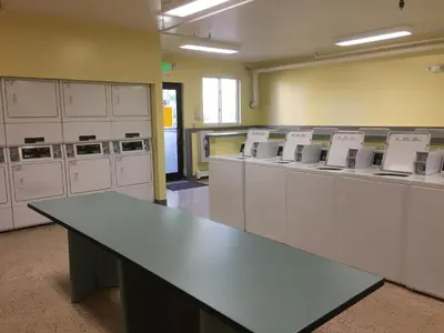 a large room with white machines and a table at Summit County Wildernest Condo in Silverthorne