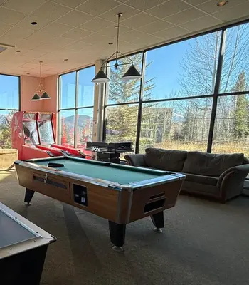 a living room with a pool table and couches at Summit County Wildernest Condo in Silverthorne
