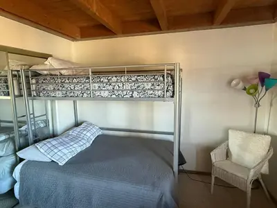a bedroom with a bunk bed and a chair at Summit County Wildernest Condo in Silverthorne
