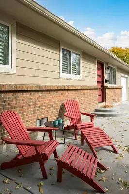 two red chairs and a table in front of a house at Cozy Family Retreat with Yard - Walk to Olde Town in Arvada