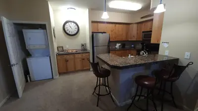 a kitchen with a counter and a clock on the wall at Meadow Ridge Mountain Views 8 minutes from Basecamp in Winter Park