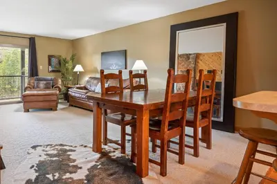 a living room with a wooden table and chairs at Ski Town Hideaway | Fireplace + Walk to Downtown in Winter Park