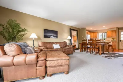 a living room with leather furniture and a dining room at Ski Town Hideaway | Fireplace + Walk to Downtown in Winter Park