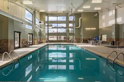 a swimming pool with blue water in a building at Ski Town Hideaway | Fireplace + Walk to Downtown in Winter Park