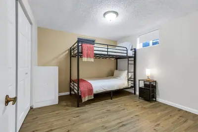a bedroom with two bunk beds and a wooden floor at 6BD Near DT - BBQ Grill, Games & Football Fun in Arvada