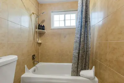 a bathroom with a tub and a toilet and a shower at 6BD Near DT - BBQ Grill, Games & Football Fun in Arvada