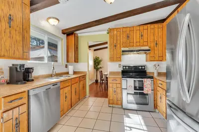 a kitchen with wooden cabinets and stainless steel appliances at 6BD Near DT - BBQ Grill, Games & Football Fun in Arvada