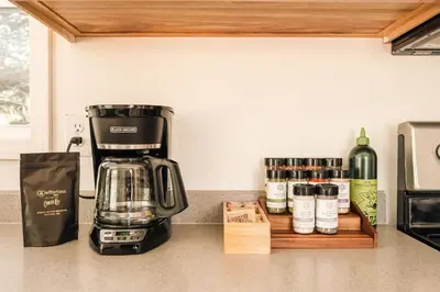 a coffeemaker sitting on a counter next to a bottle of wine at Ralston Creek Cottage - Serene Park Views in Arvada