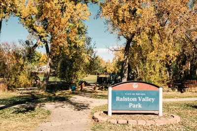 a sign in a park with trees in the background at Ralston Creek Cottage - Serene Park Views in Arvada