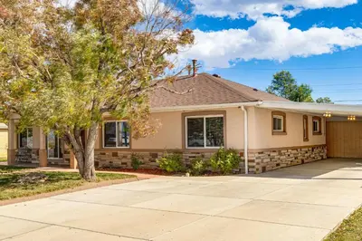 a house with a tree and a driveway at Suburban Home 9 Mi to Dtwn Denver Outdoor Oasis! in Aurora