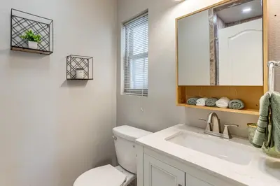 a bathroom with a toilet and a sink and a mirror at Suburban Home 9 Mi to Dtwn Denver Outdoor Oasis! in Aurora