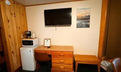 a room with a desk with a microwave and a refrigerator at Lone Eagle Lodge in Grand Lake