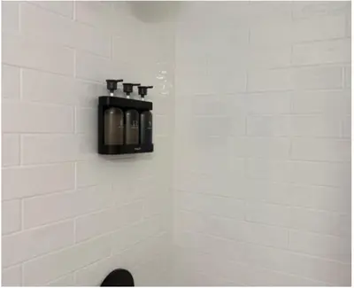 a black soap dispenser on the wall of a bathroom at Lone Eagle Lodge in Grand Lake