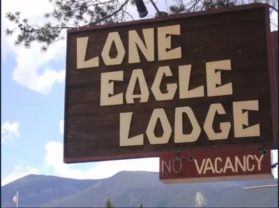 a sign for a lane eagle lodge with mountains in the background at Lone Eagle Lodge in Grand Lake