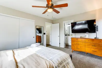 a bedroom with a bed and a flat screen tv at Fenced-In Yard with Deck Pet-Friendly Lochbuie Home