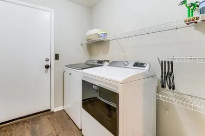 a white washer and dryer in a laundry room at Fenced-In Yard with Deck Pet-Friendly Lochbuie Home