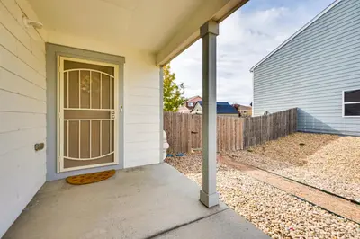 a front door of a house with a fence at Fenced-In Yard with Deck Pet-Friendly Lochbuie Home