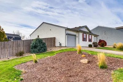 a house with a fence and a yard at Fenced-In Yard with Deck Pet-Friendly Lochbuie Home