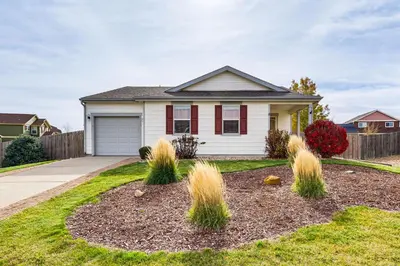 a house with a yard with grass at Fenced-In Yard with Deck Pet-Friendly Lochbuie Home