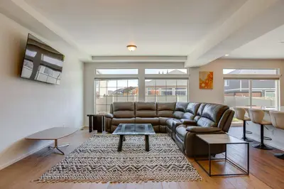 a living room with a leather couch and a table at Newly Built Home with Garage, 10 Mi to Anschutz! in Aurora