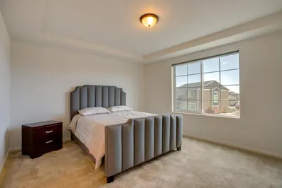 a bedroom with a large bed and a window at Newly Built Home with Garage, 10 Mi to Anschutz! in Aurora
