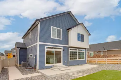 a blue house with a fence in a yard at Newly Built Home with Garage, 10 Mi to Anschutz! in Aurora