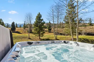 a bath tub with a view of a field at Breckenridge Stay Hot Tub Walk to Trails in Breckenridge