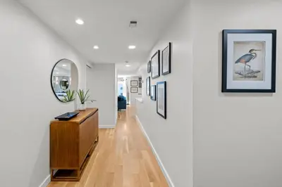 a hallway with white walls and a mirror and a dresser at 1777 Larimer 910 in Denver