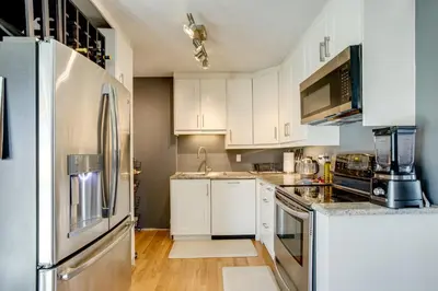 a kitchen with white cabinets and a stainless steel refrigerator at Furnished Patio! Suburban Gem 11 Mi to Dtwn Denver in Arvada