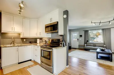 a kitchen with white cabinets and a stove top oven at Furnished Patio! Suburban Gem 11 Mi to Dtwn Denver in Arvada