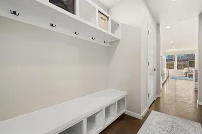 a white hallway with a white bench in a house at Comet Haus Modern 3BR with Office and King Beds in Fort Collins